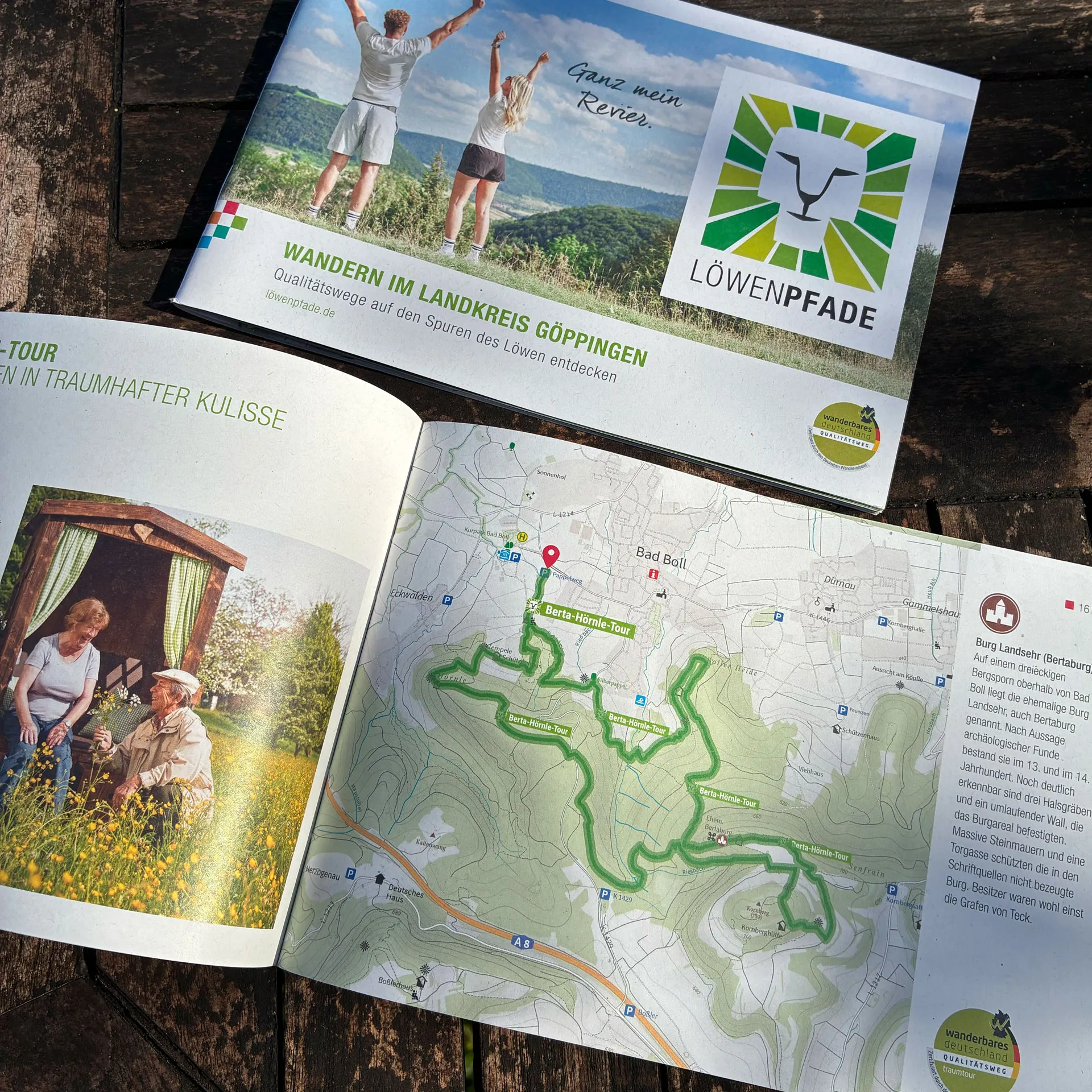 Löwenpfade Wanderbroschüre – Qualitätswege im Landkreis Göppingen entdecken Geöffnete Wanderbroschüre von Löwenpfade mit dem Titel 'WANDERN IM LANDKREIS GÖPPINGEN – Qualitätswege auf den Spuren des Löwen entdecken'. Das Cover zeigt zwei wandernde Personen auf einer Anhöhe mit dem Slogan 'Ganz mein Revier.' und dem Löwenpfade-Logo. Innen sind eine detaillierte Wanderkarte mit grün markierten Routen sowie Fotos von Natur und lokalen Motiven zu sehen.